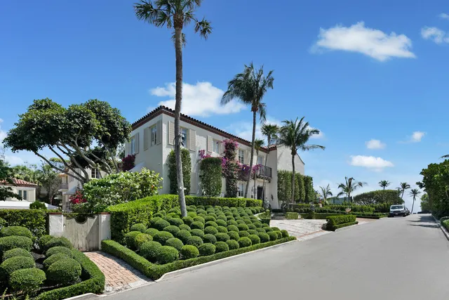 a front view of a house with a yard and potted plants