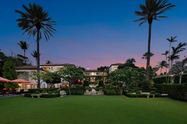 a front view of multi story residential apartment building with yard and green space