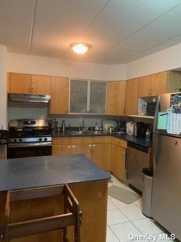 a kitchen with stainless steel appliances a stove a sink and a microwave