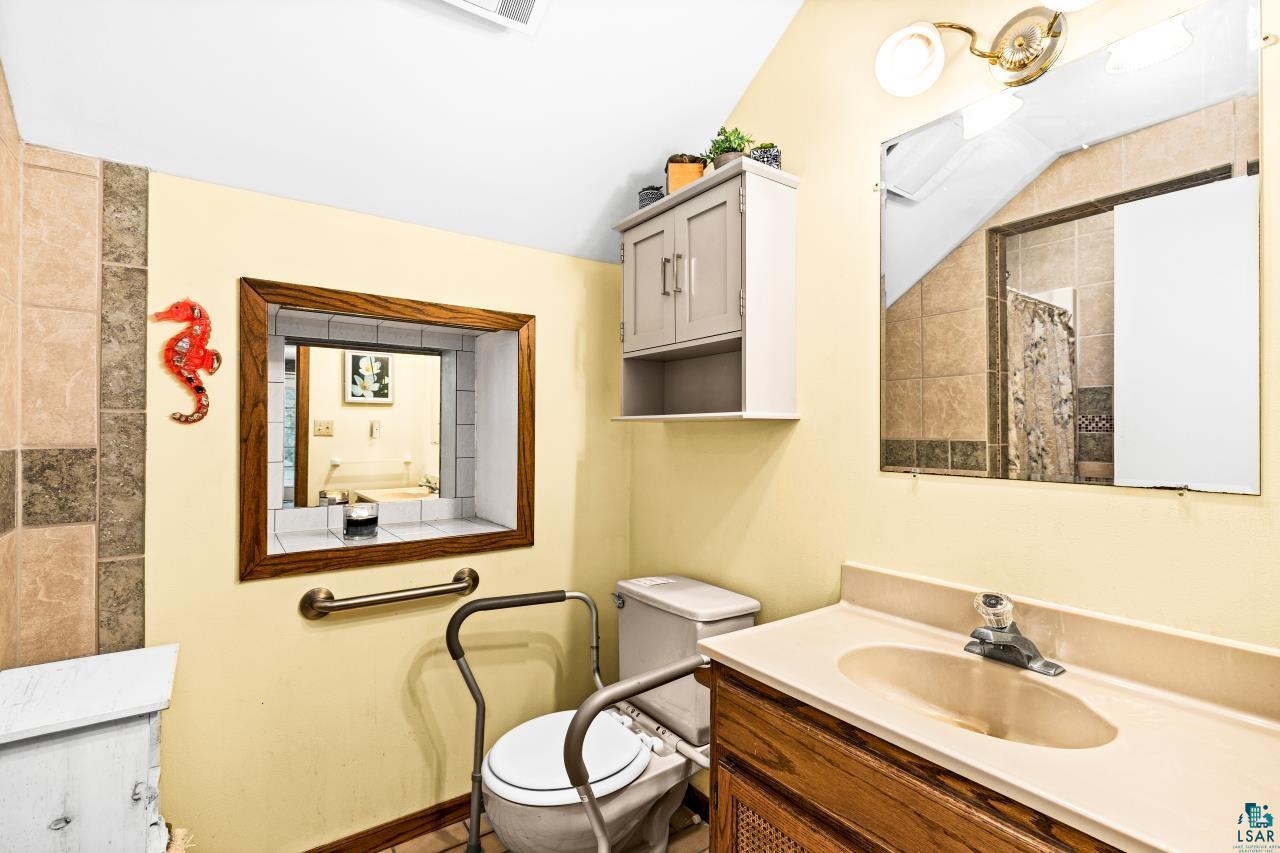 3723 Birchwood Road Kettle River, MN 55757 - Photo 21 of 48 Bathroom with vanity, a tile shower, and vaulted ceiling