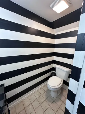 a bathroom with a toilet and a shower curtain