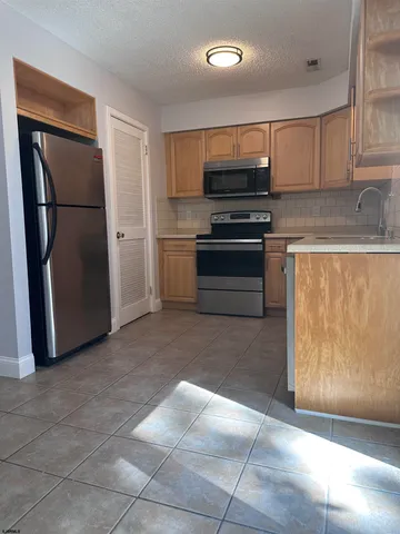 a kitchen with stainless steel appliances granite countertop a refrigerator stove and cabinets