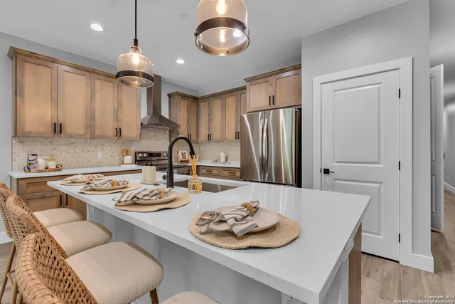 a kitchen with stainless steel appliances granite countertop a sink stove and refrigerator with wooden floor