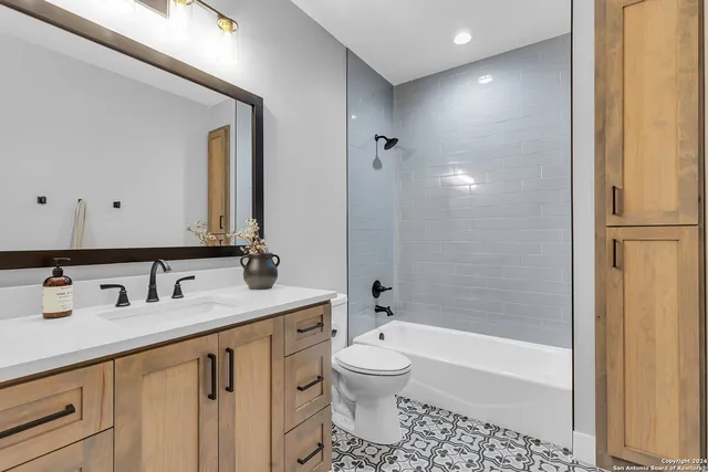 a bathroom with a sink a toilet and shower