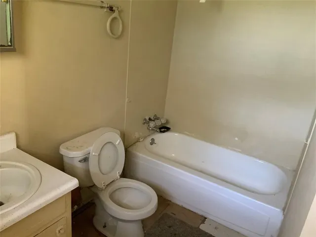 a white toilet sitting next to a bath tub