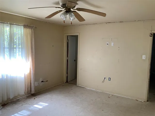 en empty room with windows and fan