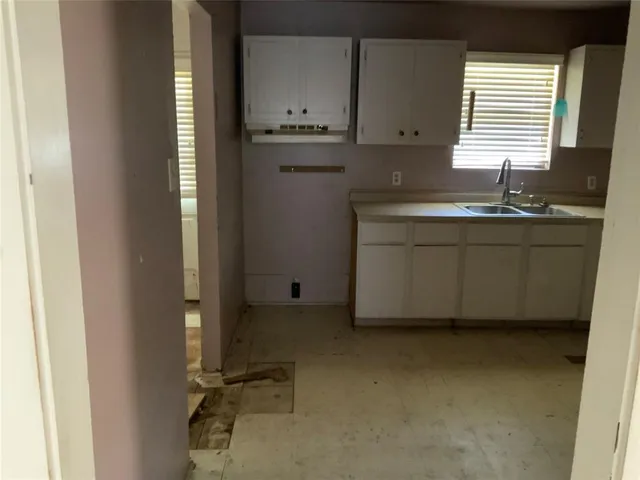 a room with a sink cabinets and a window