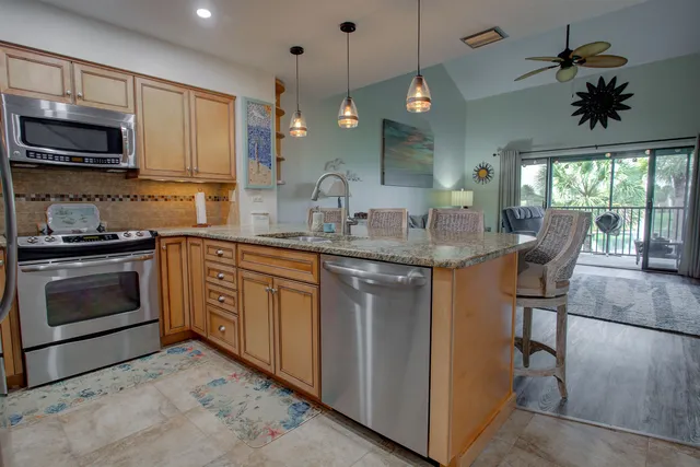 a kitchen with stainless steel appliances granite countertop a stove a sink and a microwave