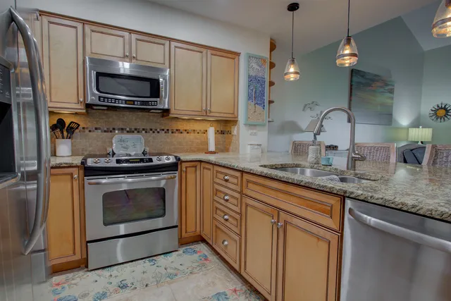 a kitchen with stainless steel appliances granite countertop a sink a stove a microwave and cabinets