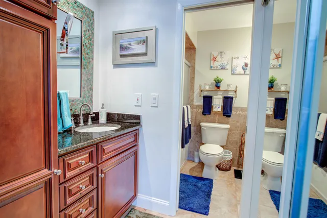 a bathroom with a granite countertop sink and a mirror