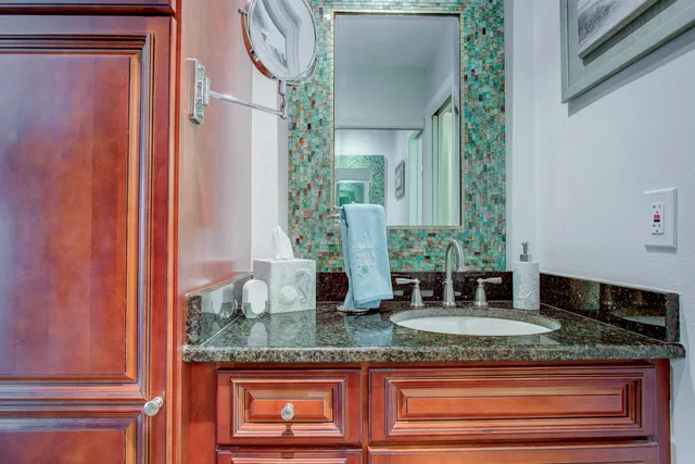 a bathroom with mirror and vanity