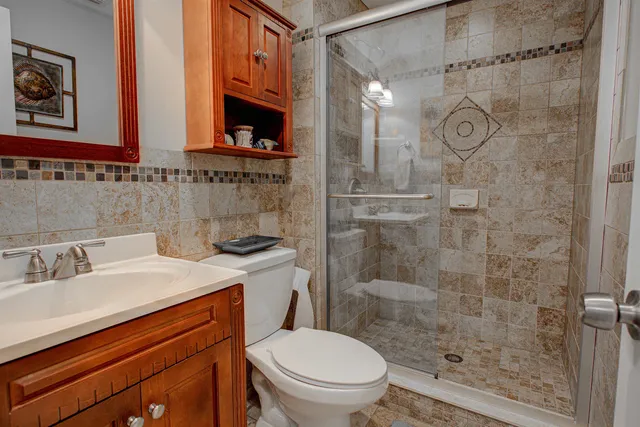 a bathroom with a sink a toilet and shower