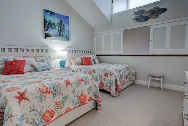 a bedroom with two beds and painting on the wall