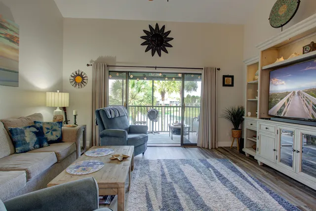 a living room with furniture a flat screen tv and a floor to ceiling window