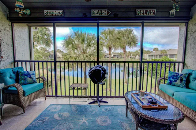 a view of a porch with furniture and a yard