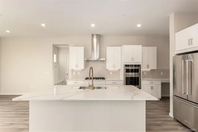 a kitchen with kitchen island a sink and refrigerator
