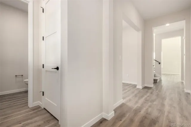 a view of a room with wooden floor and a bathroom