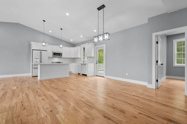 a view of empty room with wooden floor and window