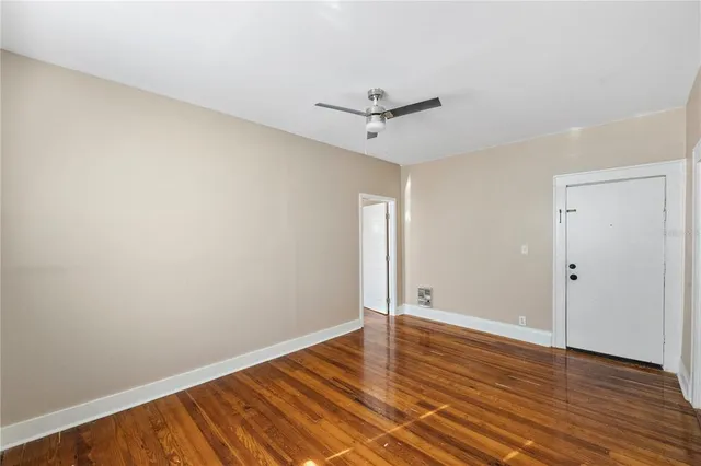 a view of empty room with wooden floor