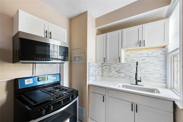 a kitchen with stainless steel appliances a sink stove and microwave