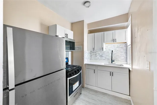 a kitchen with stainless steel appliances a refrigerator sink and cabinets