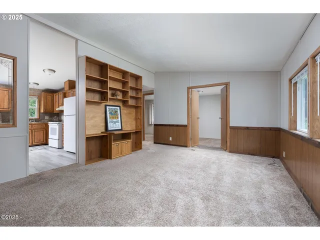 a view of empty room with furniture and refrigerator