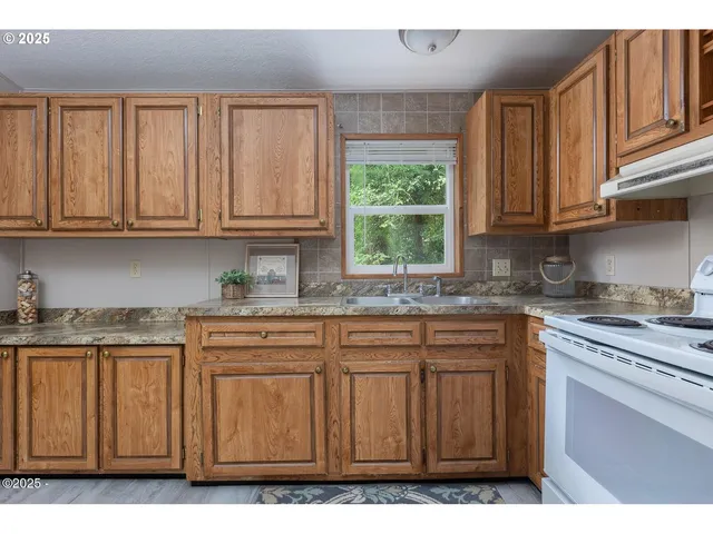 a kitchen with granite countertop cabinets stainless steel appliances a sink and window