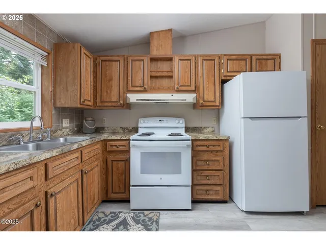 a kitchen with a refrigerator stove and white cabinets