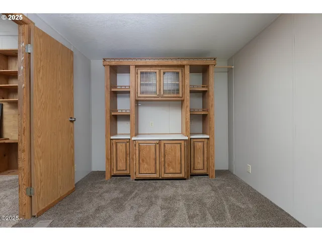 a view of an empty room with wooden shelves