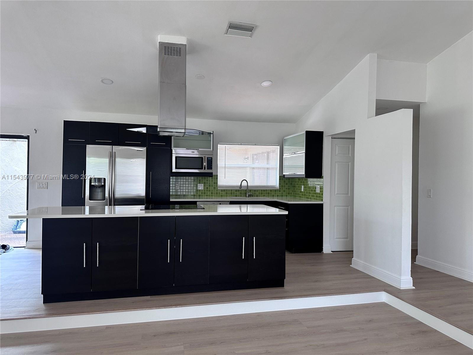 a view of kitchen with stainless steel appliances granite countertop cabinets and wooden floor
