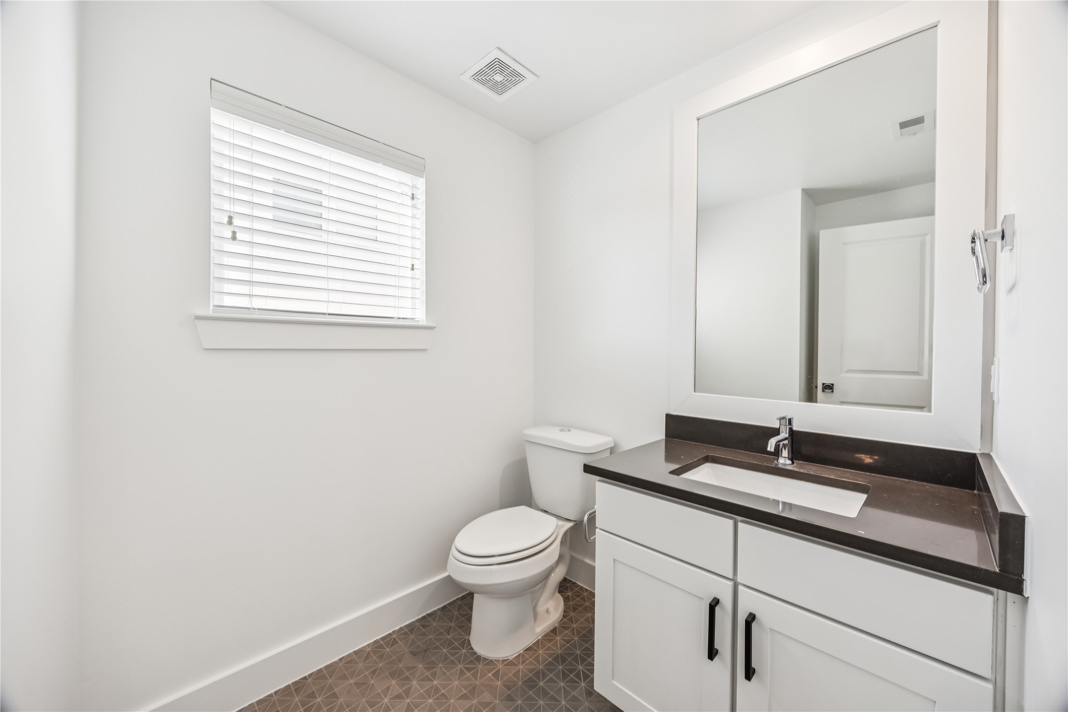 1812 West Webster Street Houston, TX 77019 - Photo 14 of 23 a bathroom with a granite countertop toilet a sink and a mirror