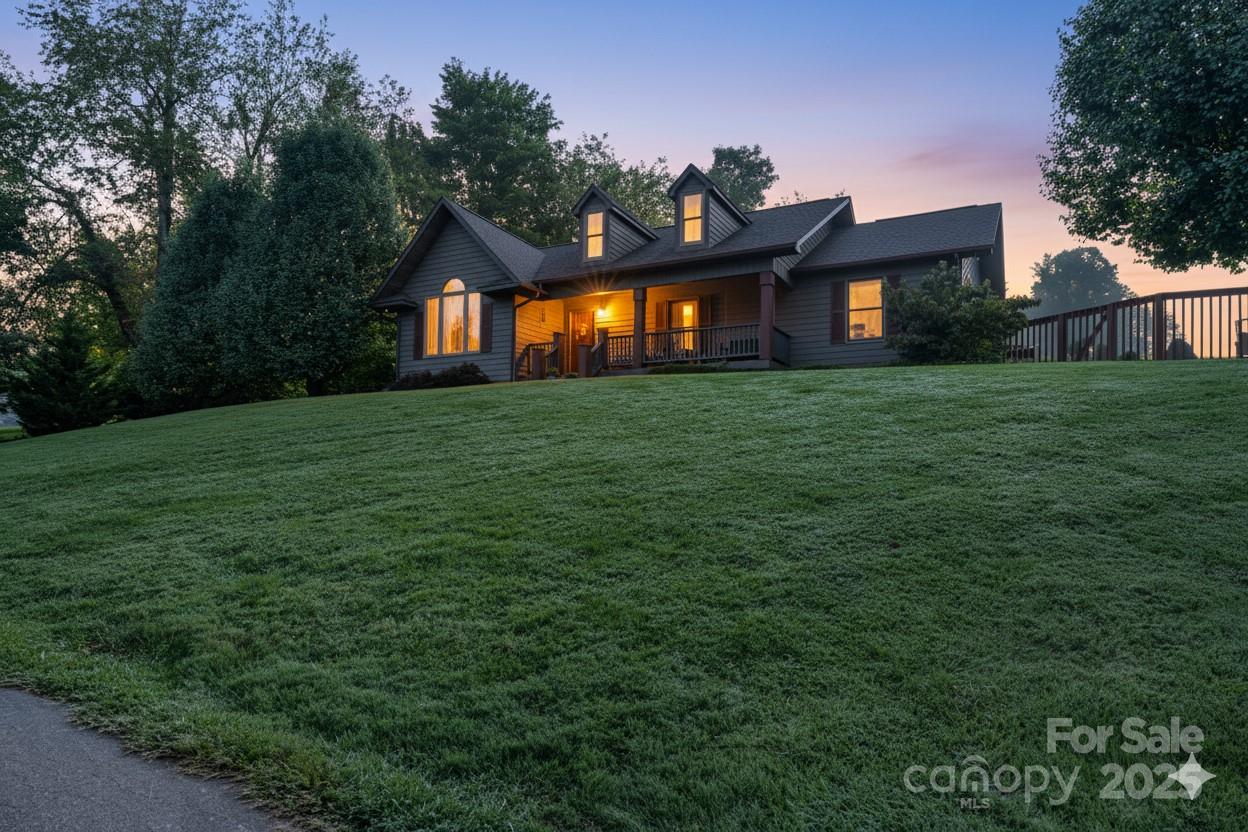 57 Stillwater Springs Road Burnsville, NC 28714 - Photo 1 of 48 a front view of house with yard and trees in the background