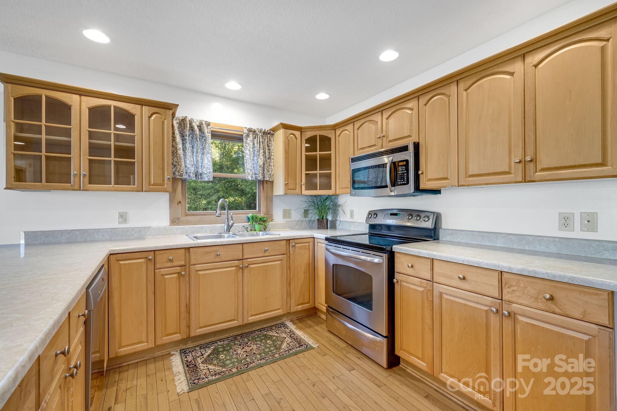 57 Stillwater Springs Road Burnsville, NC 28714 - Photo 20 of 48 a kitchen with stainless steel appliances granite countertop a stove a sink and a microwave