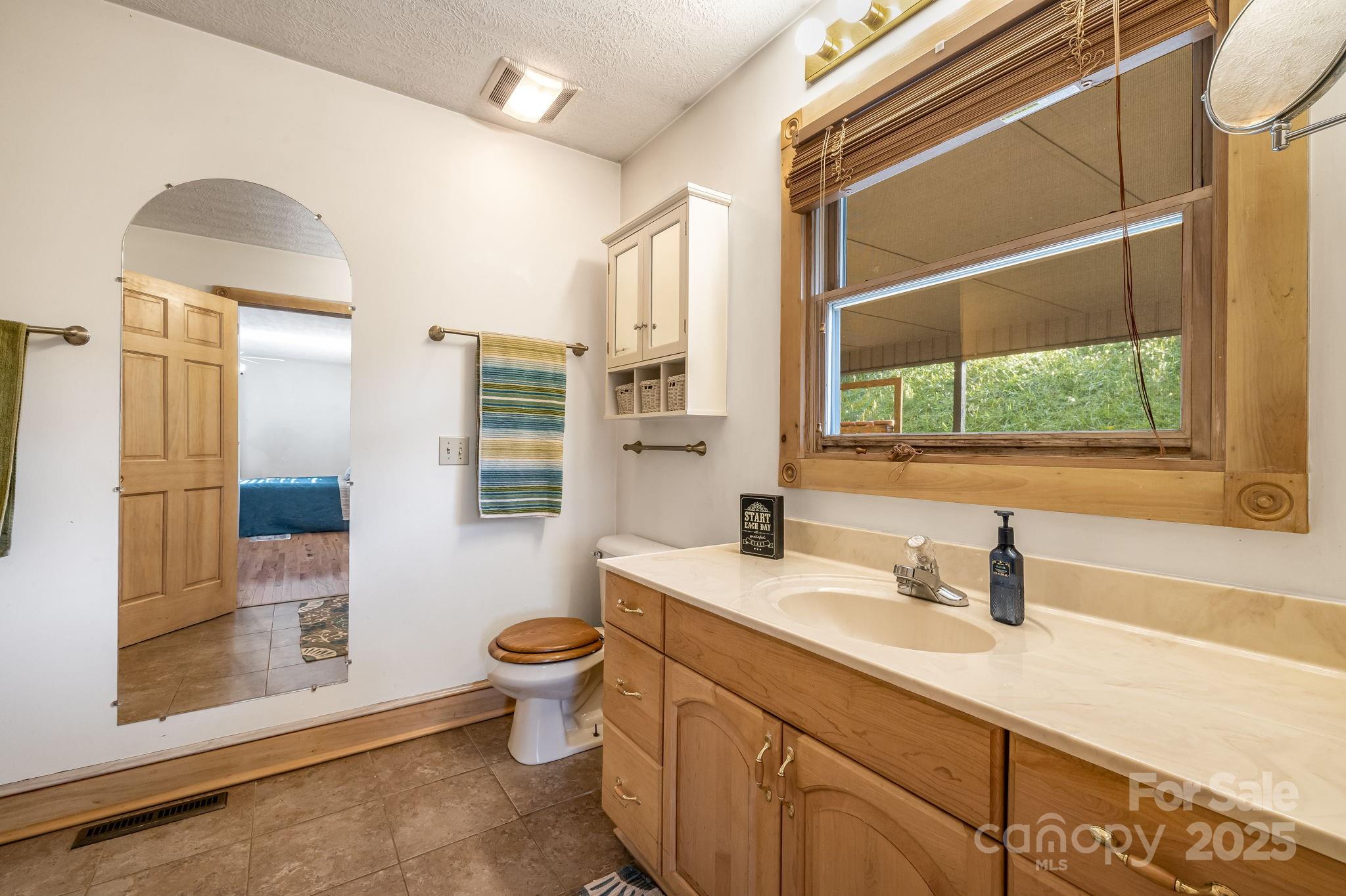 57 Stillwater Springs Road Burnsville, NC 28714 - Photo 28 of 48 a bathroom with a sink toilet a mirror and shower