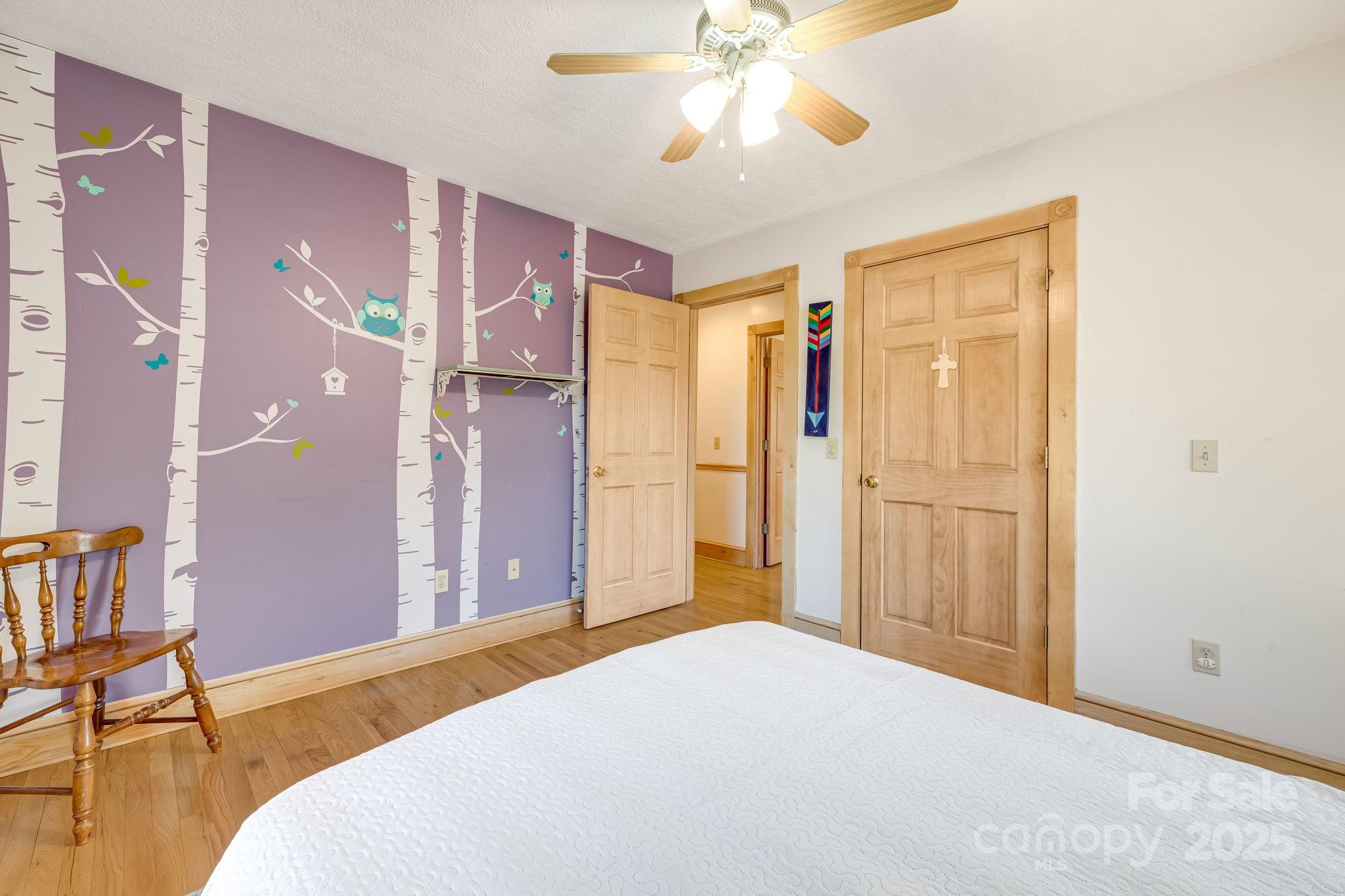 57 Stillwater Springs Road Burnsville, NC 28714 - Photo 31 of 48 a bedroom with a bed and a chandelier