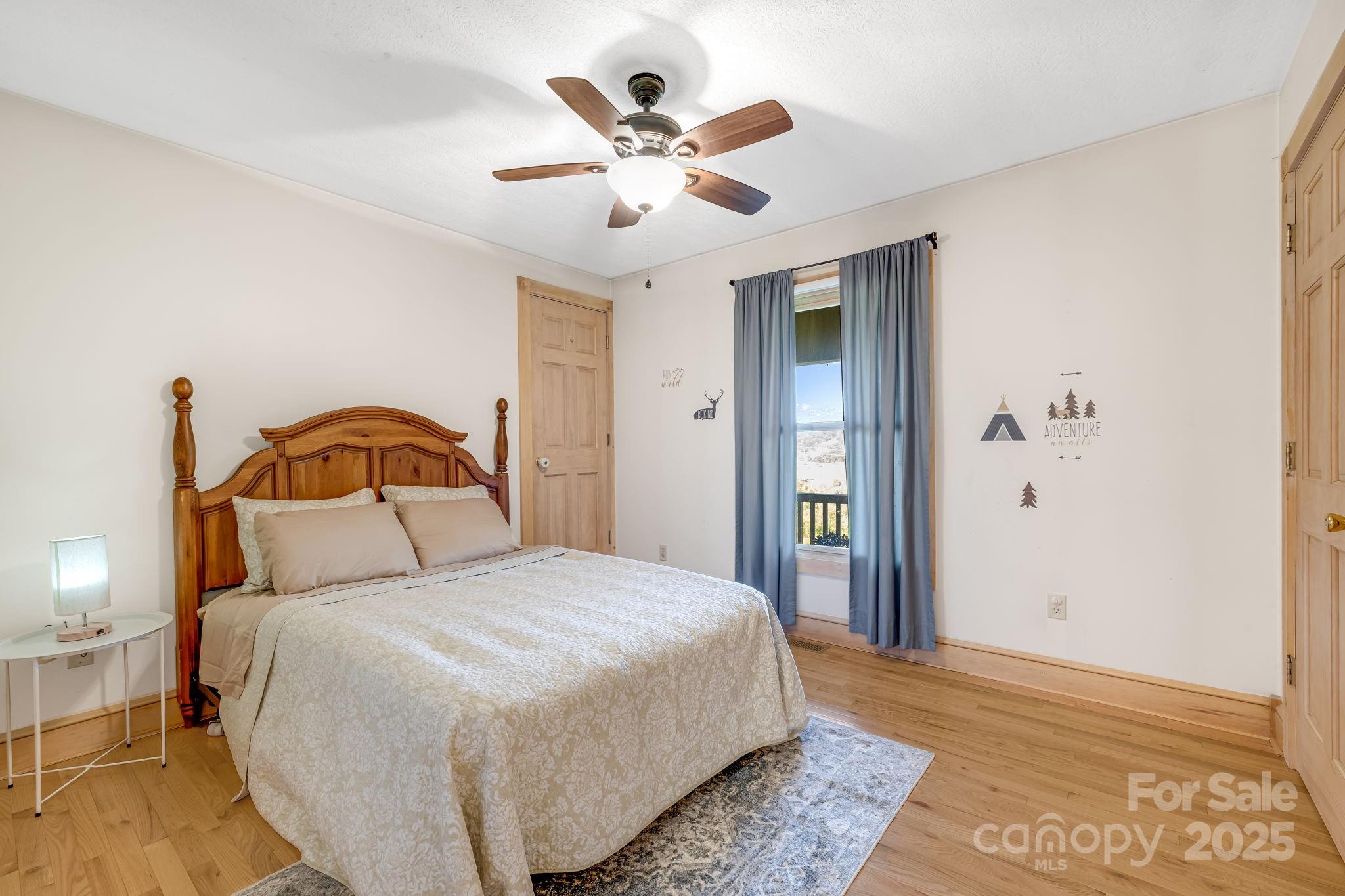 57 Stillwater Springs Road Burnsville, NC 28714 - Photo 32 of 48 a bedroom with a large bed and a ceiling fan