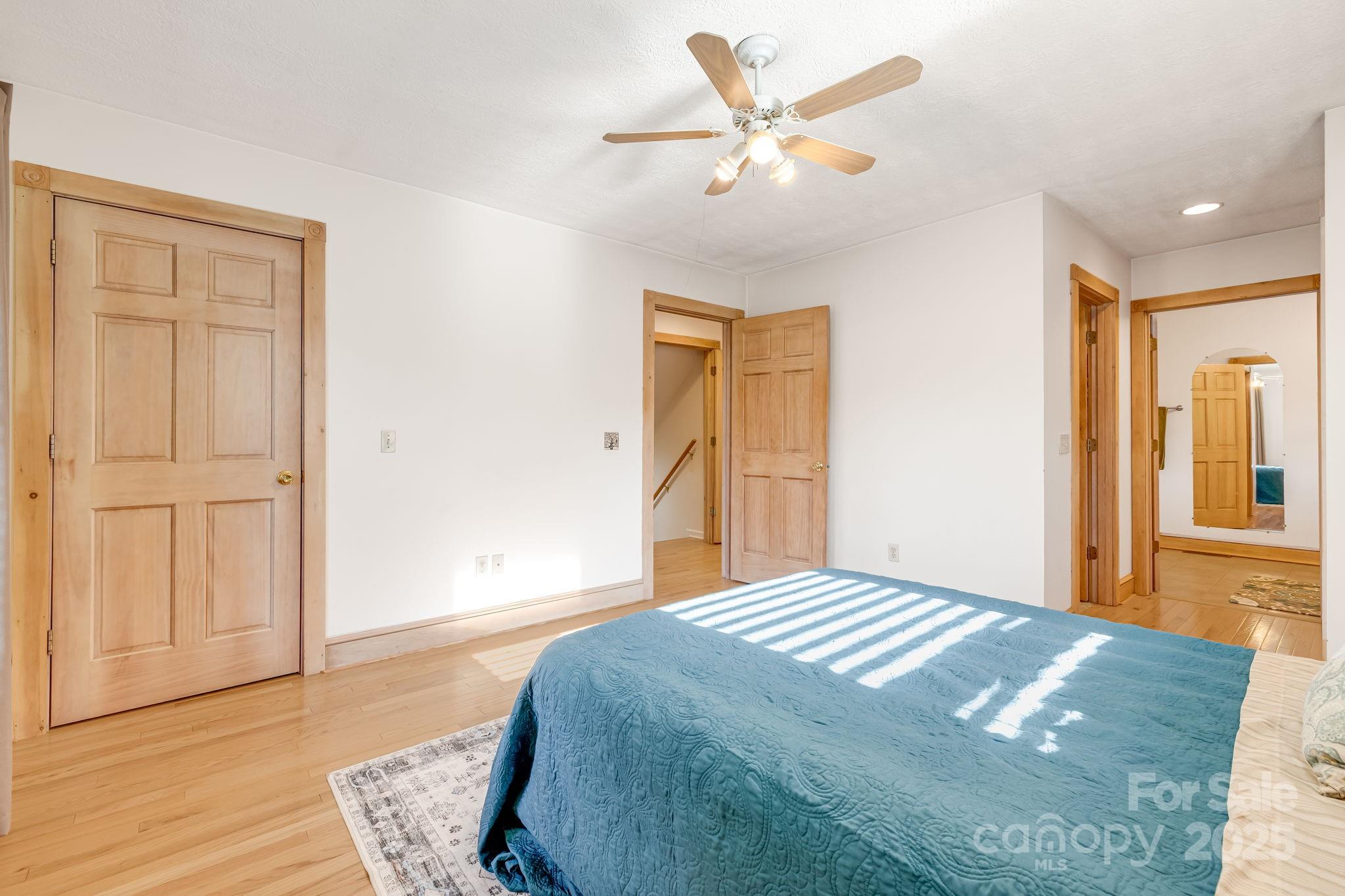 57 Stillwater Springs Road Burnsville, NC 28714 - Photo 5 of 48 a bedroom with a bed and a chandelier