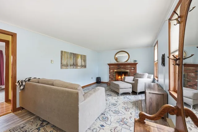 a living room with furniture a rug a fireplace and a window
