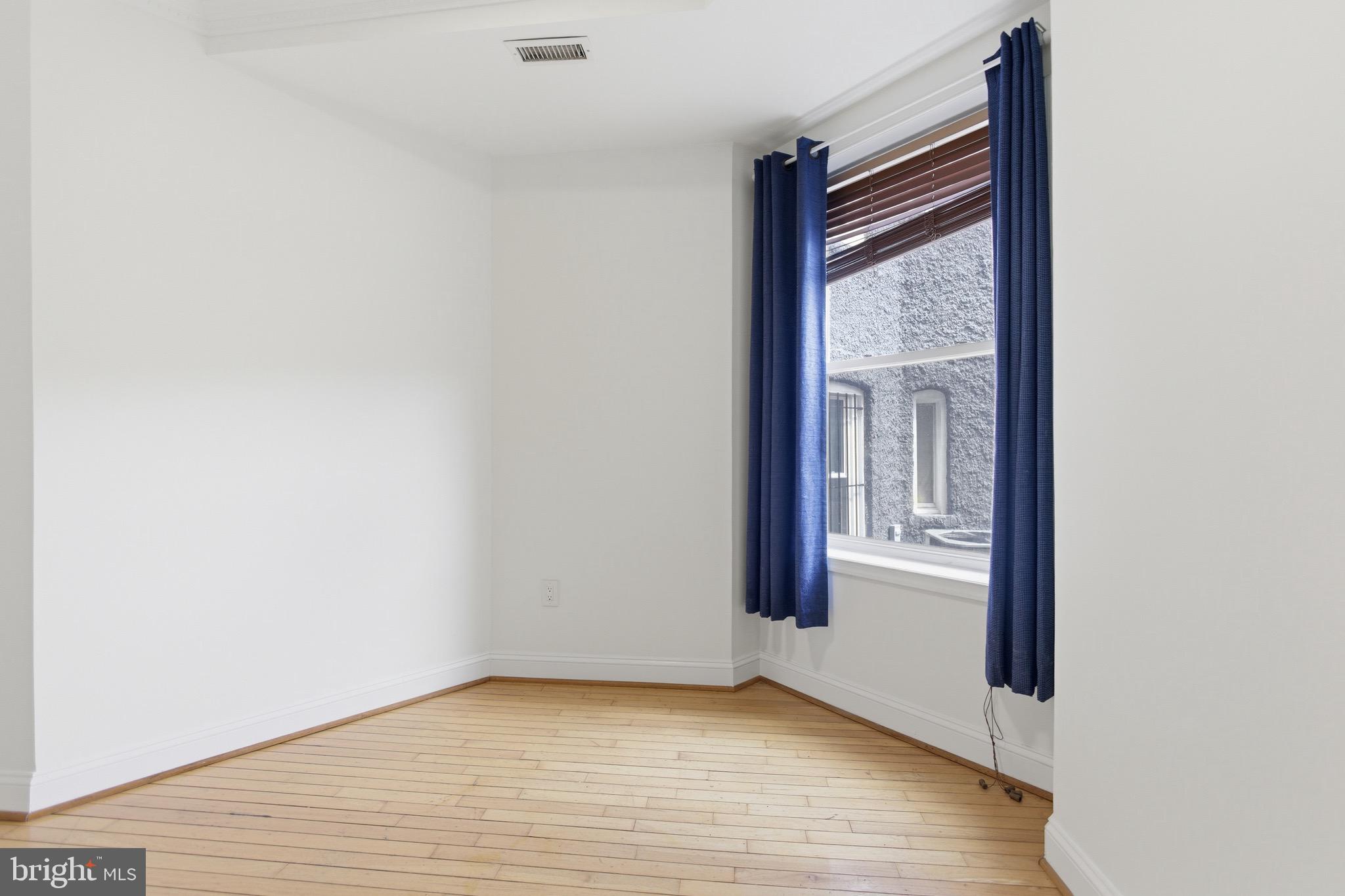 636 Columbia Road Northwest Washington, DC 20001 - Photo 31 of 60 a view of an empty room with wooden floor and a window