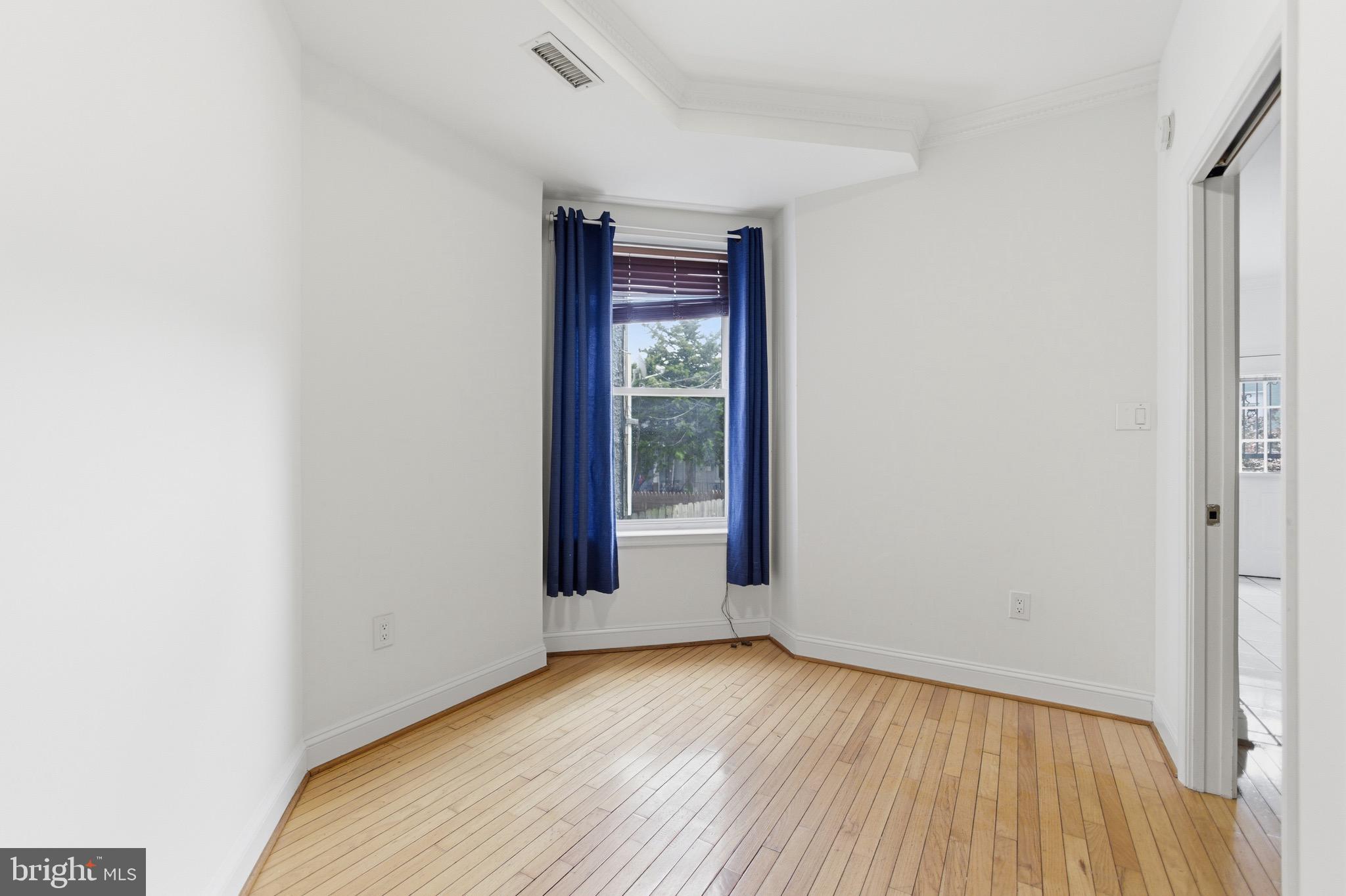 636 Columbia Road Northwest Washington, DC 20001 - Photo 33 of 60 a view of an empty room with wooden floor and a window