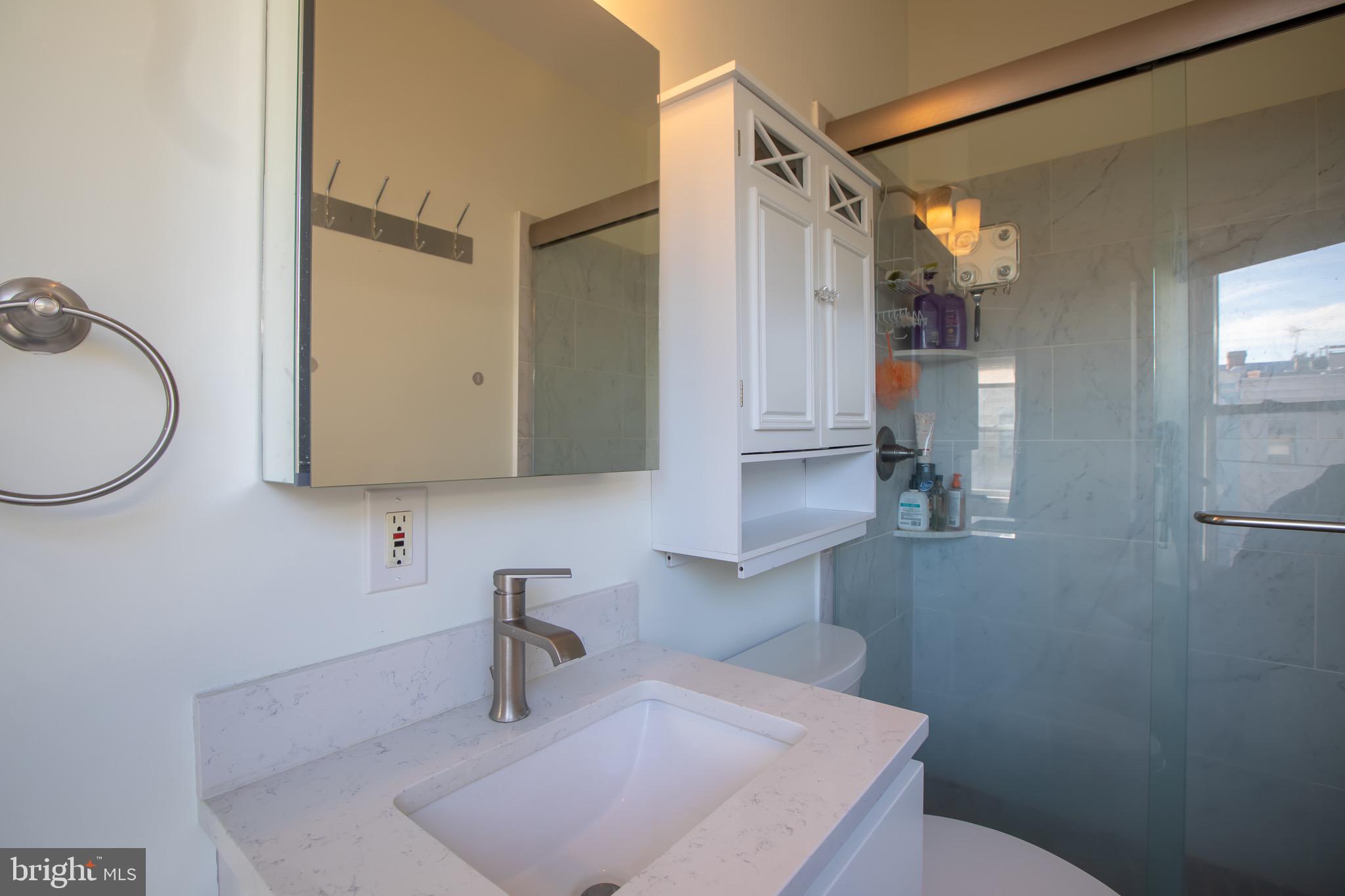 636 Columbia Road Northwest Washington, DC 20001 - Photo 46 of 60 a bathroom with a sink a toilet and a mirror