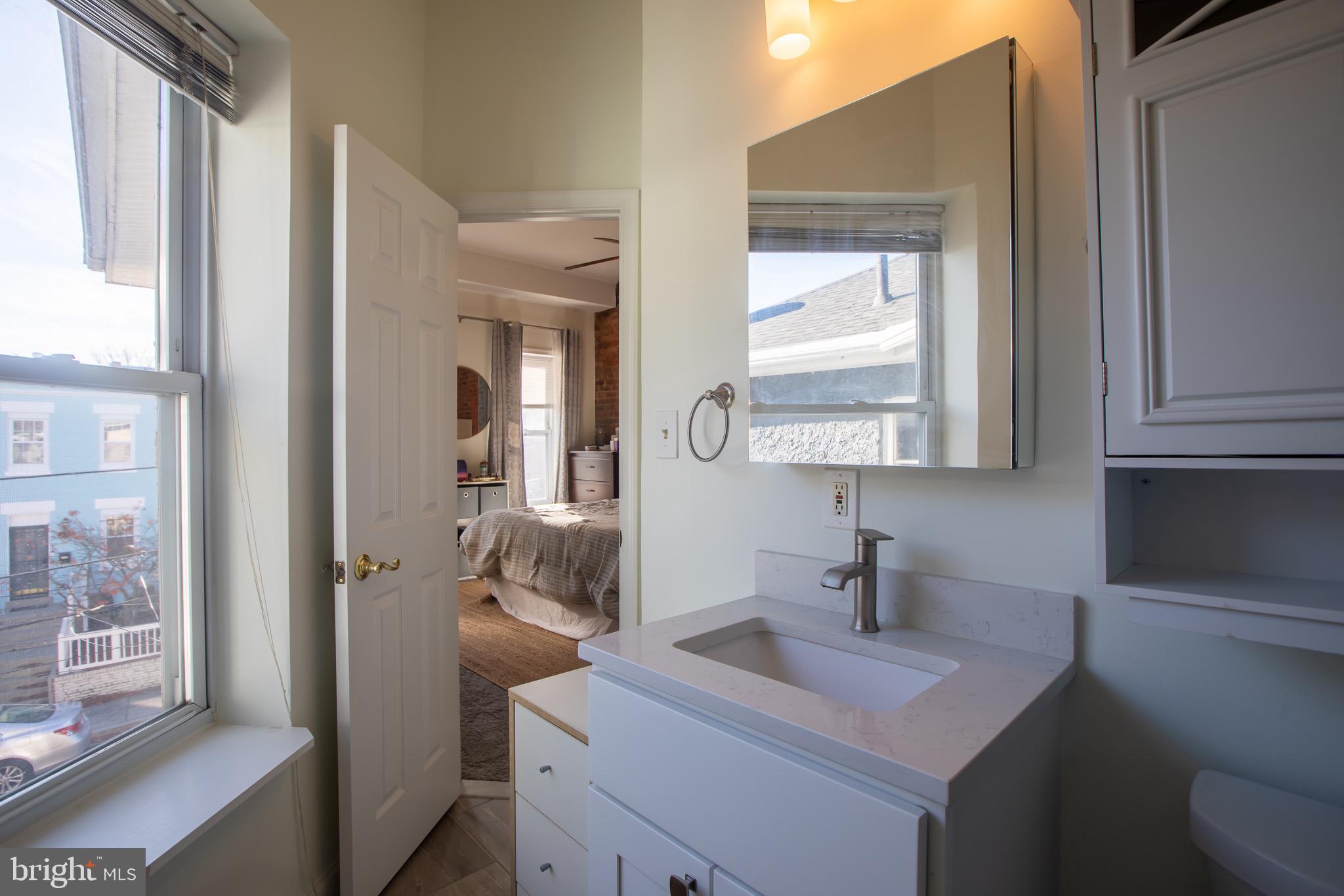 636 Columbia Road Northwest Washington, DC 20001 - Photo 47 of 60 a bathroom with a sink a toilet and mirror