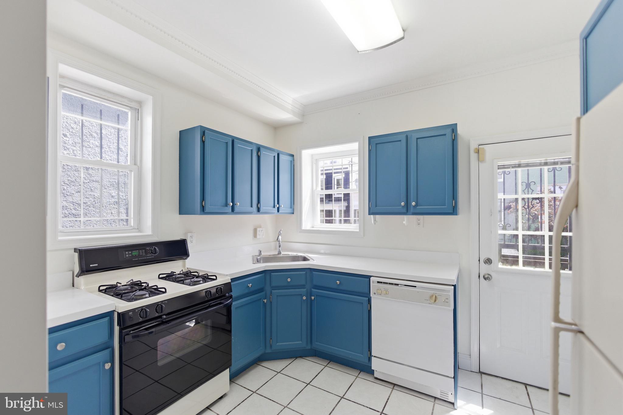 636 Columbia Road Northwest Washington, DC 20001 - Photo 10 of 60 a kitchen with a stove a sink and a window