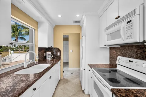 a kitchen with stainless steel appliances granite countertop a sink stove and cabinets