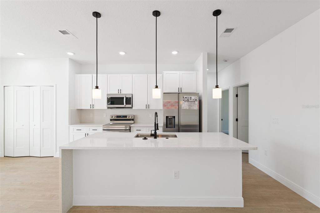 3350 Southwest 129th Loop Ocala, FL 34473 - Photo 11 of 33 a kitchen with stainless steel appliances kitchen island granite countertop a sink a center island a stove and a wooden floor