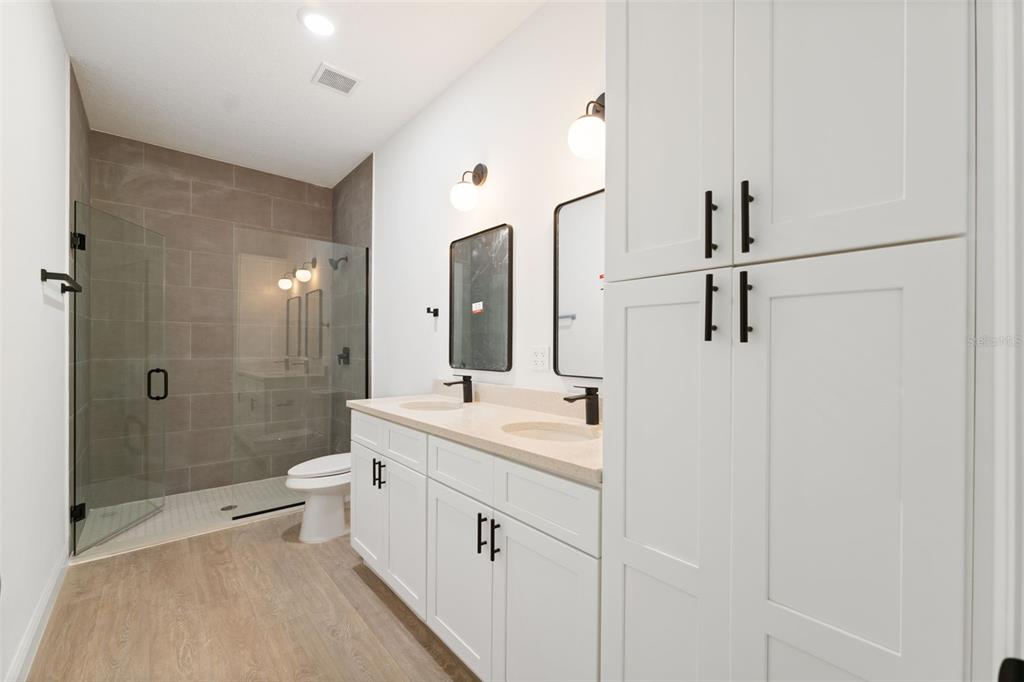 3350 Southwest 129th Loop Ocala, FL 34473 - Photo 19 of 33 a bathroom with a double vanity sink toilet mirror and shower