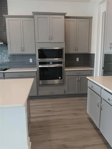 a kitchen with granite countertop white cabinets and stainless steel appliances