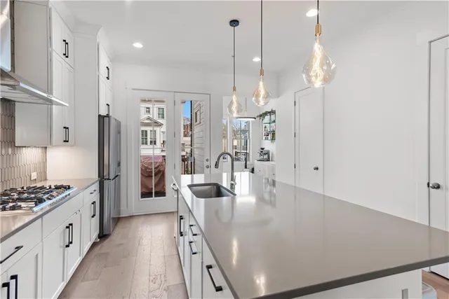 a kitchen with stainless steel appliances granite countertop a sink stove and cabinets