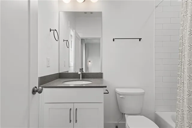 a front view of a house with a garden and tree