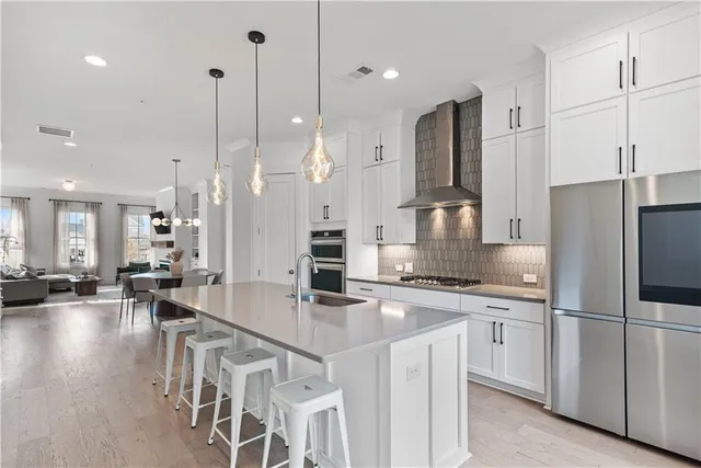 a kitchen with stainless steel appliances granite countertop a sink a refrigerator and a stove